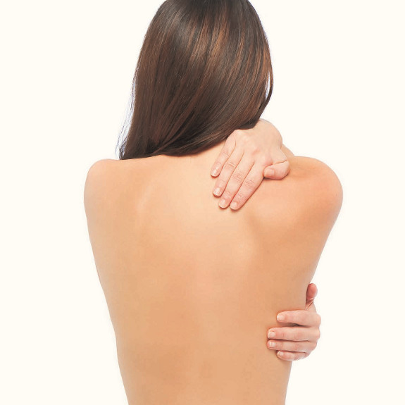 Sanfte Pflege: Frau trägt pflegendes Öl auf ihren Rücken auf